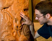 A visitor admiring some Maori carvings