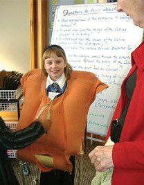 A student tries on a life jacket